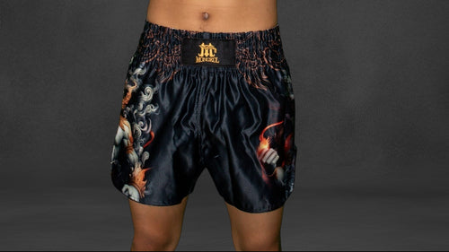 Person wearing boxing gloves and shorts on a dark background